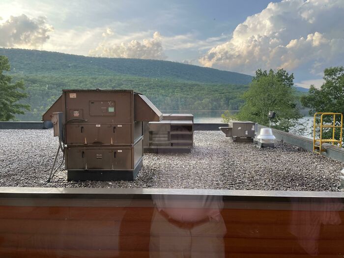 Rooftop view with air conditioning units overlooking mountains and trees, symbolizing regretful spending decisions.