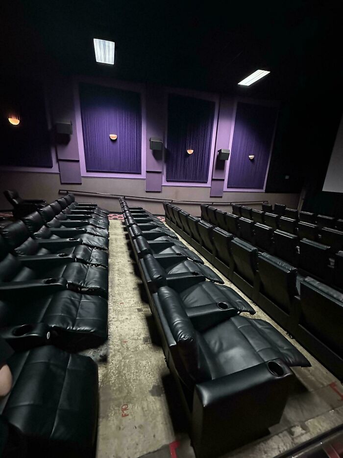 Empty movie theater with a missing row of seats, creating an uneven arrangement.