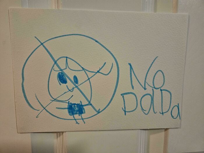 Child's blue marker drawing with a crossed-out figure and handwritten words no dad, showcasing funny dads doing their best.