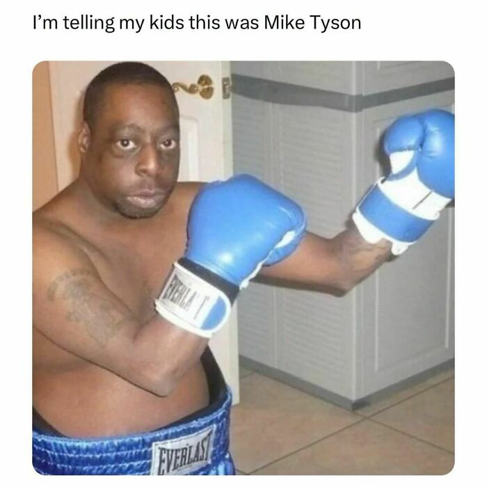 Man wearing blue boxing gloves and shorts in a humorous post showing everyone’s barely holding it together.