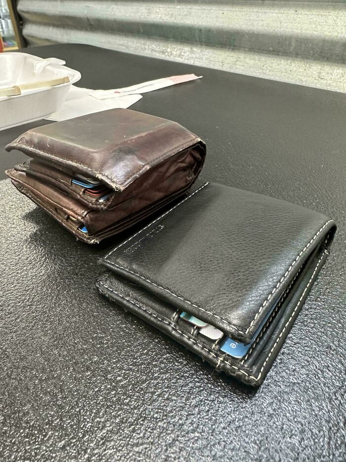 Two large, overstuffed wallets on a black table, illustrating absolute units in everyday things.
