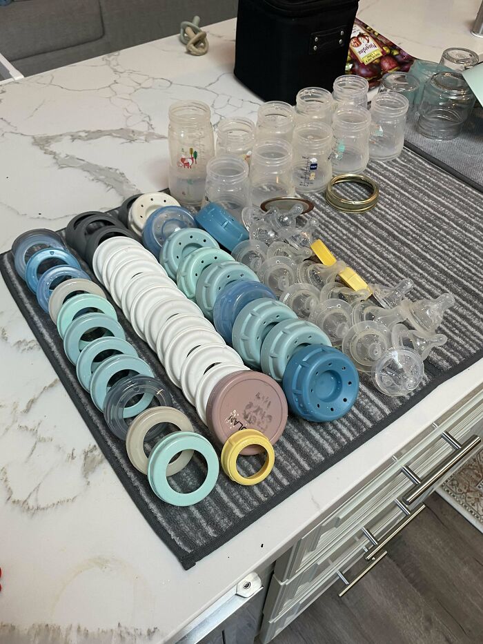 Many baby bottle parts neatly organized and drying on a mat, showing wholesome and funny dads doing their best.
