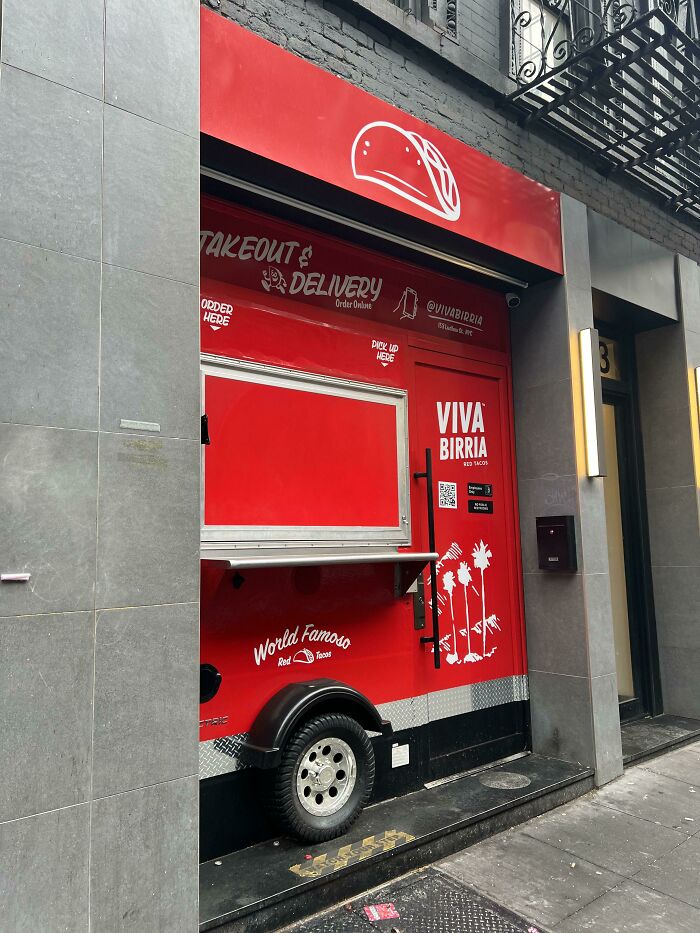 Red takeout restaurant creatively designed as a food truck embedded in a doorway, showcasing designer innovation.