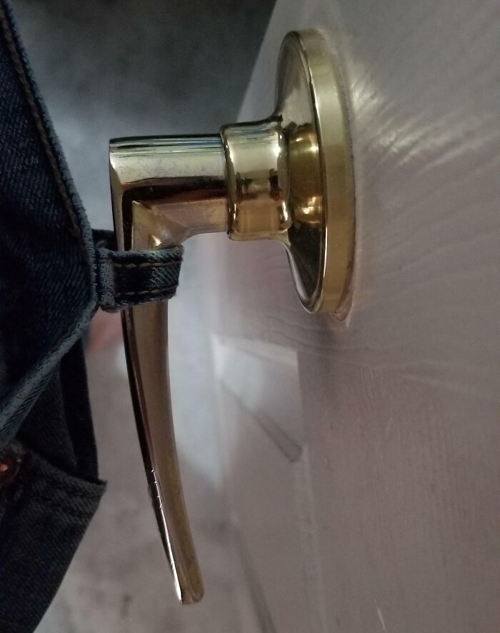 Jeans belt loop caught on a door handle, illustrating an irritating things moment.