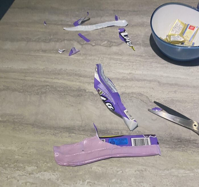 Messy table with broken candy wrappers and scissors, an irritating scene of incomplete cleaning.