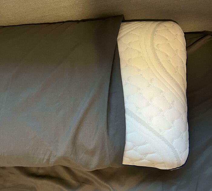 Misaligned pillow inside a black pillowcase, showcasing an irritating imperfection in bedding arrangement.