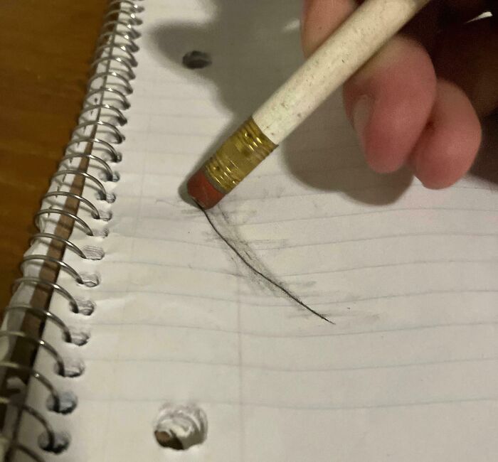 Pencil eraser smudging a page in a spiral notebook, illustrating a common irritating mistake.