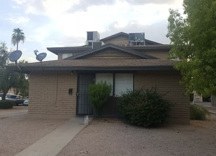 Brick house with satellite dishes captured on Google Street View, showcasing a typical suburban life scene.