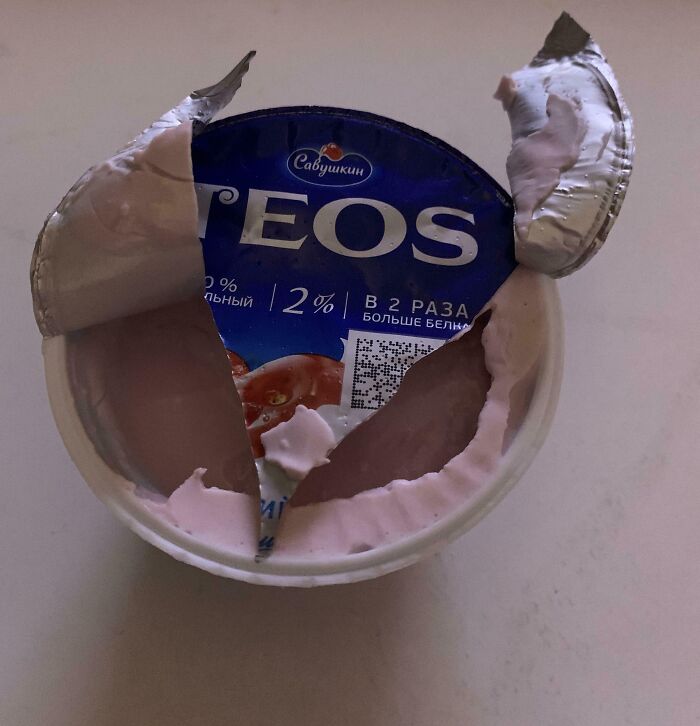 Yogurt lid tear reveals half of the content, highlighting irritating packaging issues.