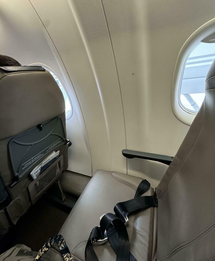 Airplane seat misaligned with window, illustrating mildly infuriating things in travel.
