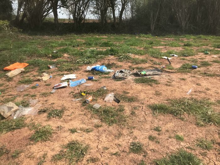 Litter scattered across a field, illustrating inconsiderate behavior.