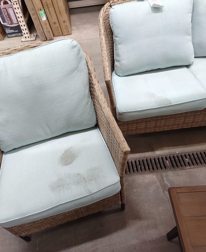 Dirty patio furniture cushions in a store, showing signs of people being jerks.