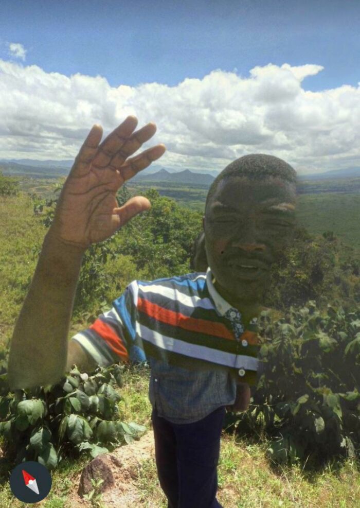 A distorted figure waves on a hillside, capturing one of the weird life scenes on Google Street View.