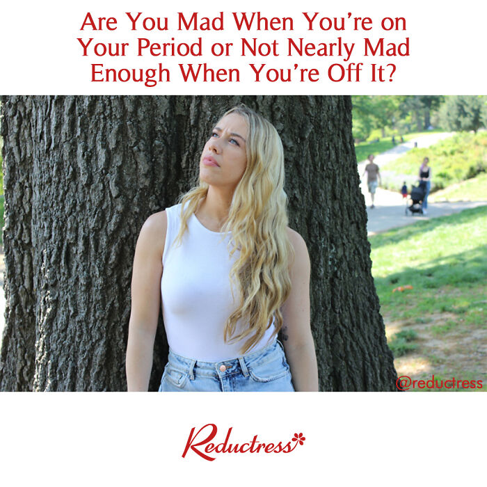 Woman in a white tank top leans against a tree, reflecting on a humorous fake headline about emotions and periods.