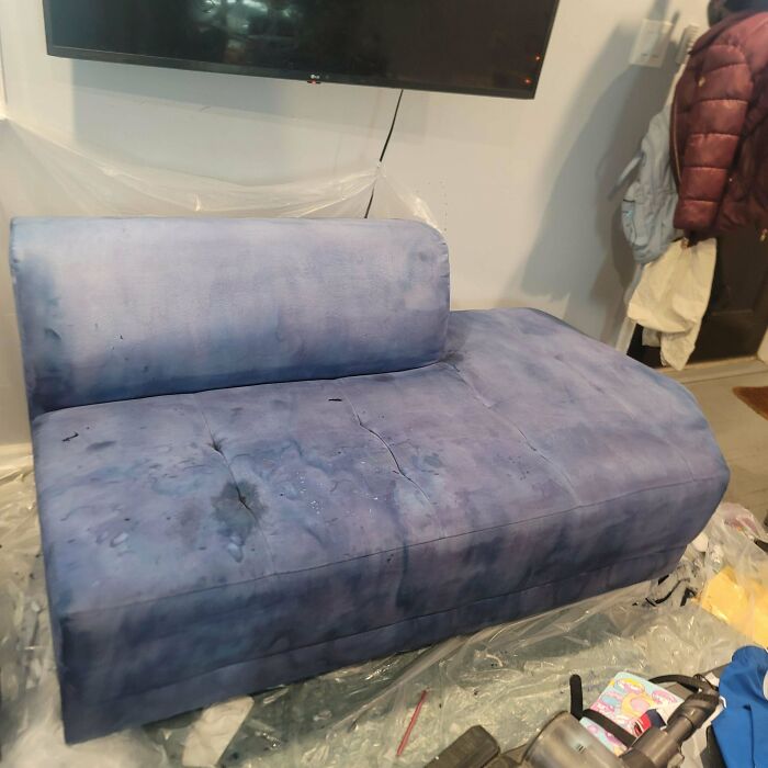 Blue sofa with uneven staining and visible damage, an example of DIY disasters in home furniture projects.