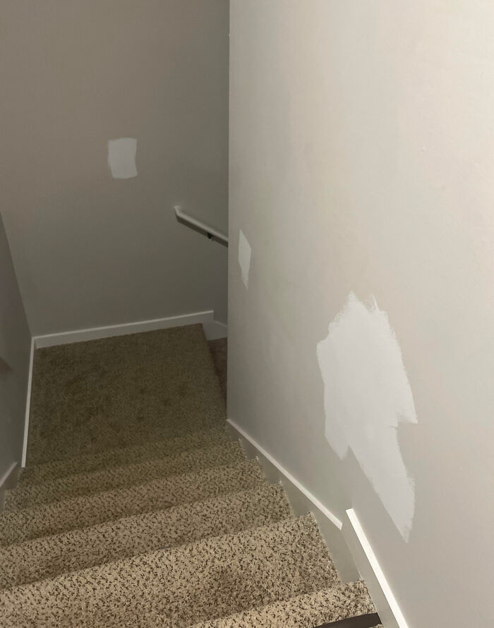 Stairway with mismatched paint patches, illustrating home improvement fails and a challenging day for renovators.