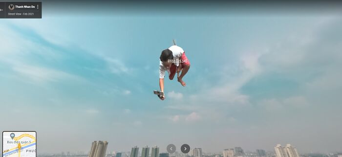 Person caught mid-air in a surreal scene on Google Street View over a city skyline, embodying funny and weird life moments.