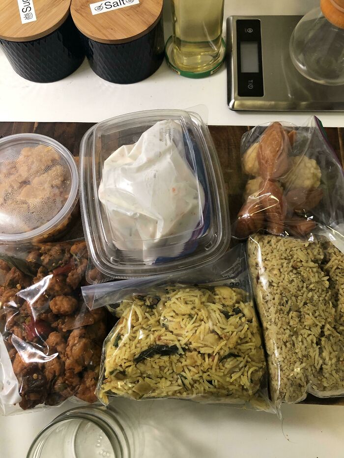 Thanksgiving feast with assorted homemade dishes in containers on a kitchen counter.