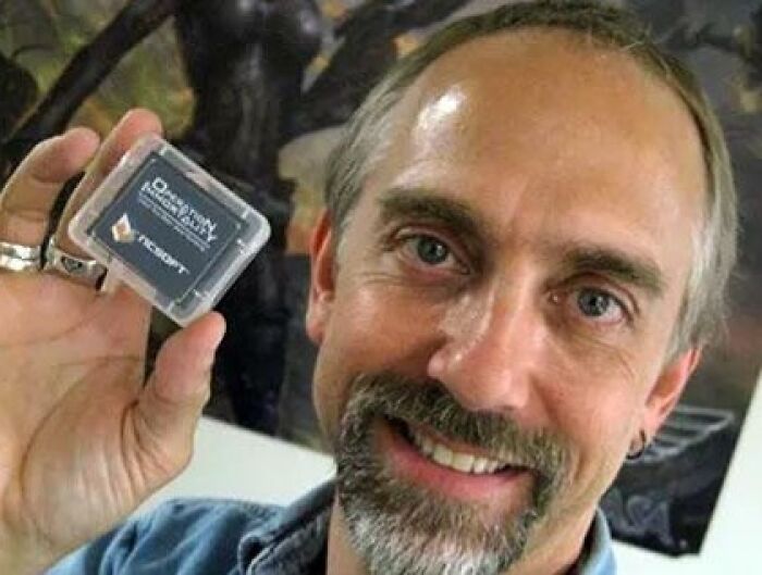 Man holding a small historical time capsule, smiling at the camera.