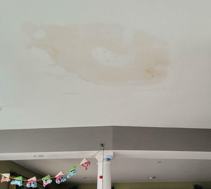 Ceiling stain from a home improvement fail, with decorative train bunting below.