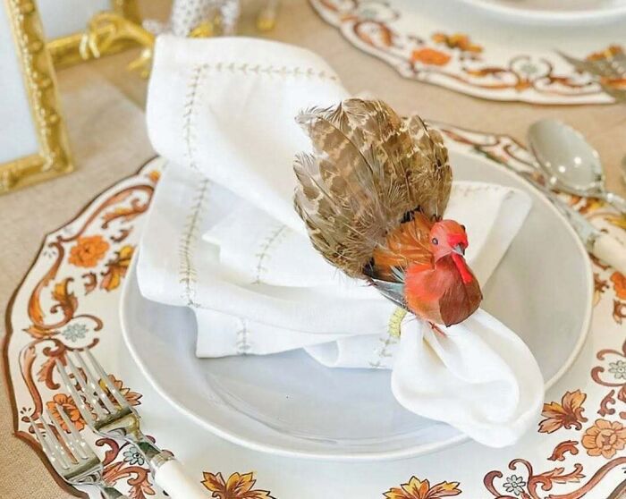 Thanksgiving home decoration with a turkey napkin holder on a festive table setting.