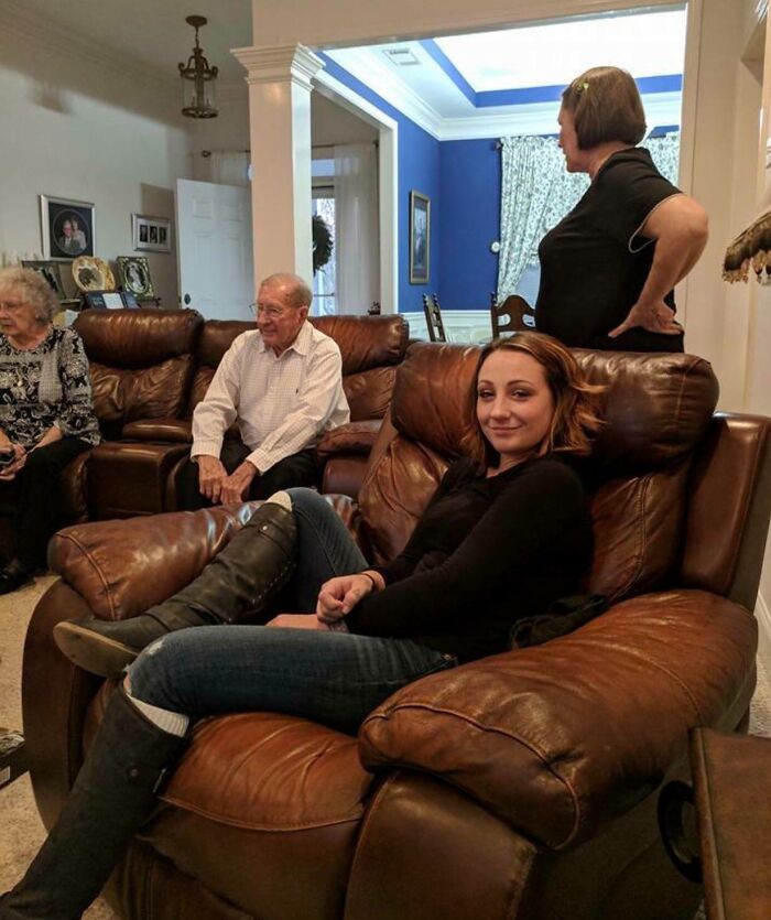 Family gathered in cozy living room, enjoying Thanksgiving together on comfortable leather chairs.