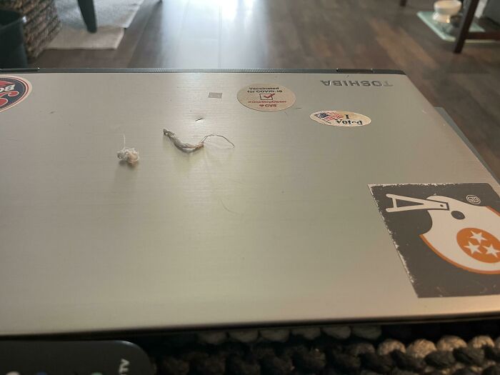 Toshiba laptop with stickers, representing the idea of weaponized incompetence; untidy surface.