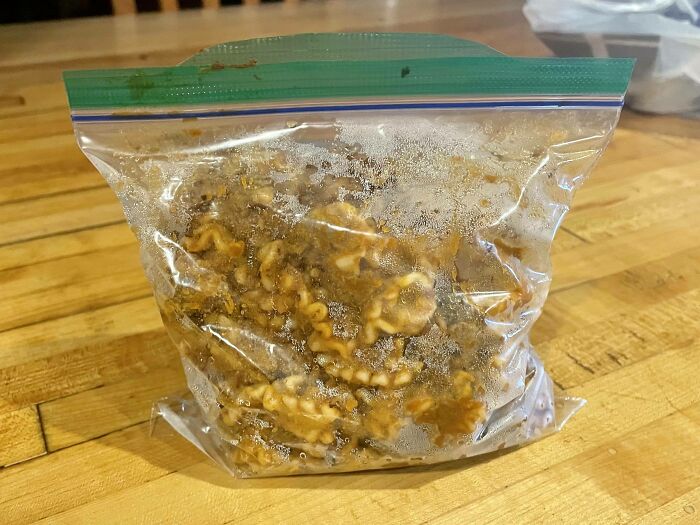 A frozen bag of walnuts on a wooden table, illustrating weaponized incompetence in food storage.