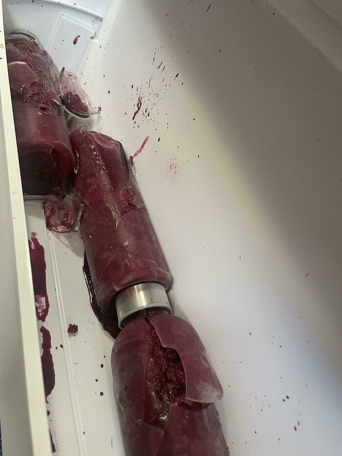 Broken bottles with spilled purple liquid, illustrating weaponized incompetence in a careless mess.