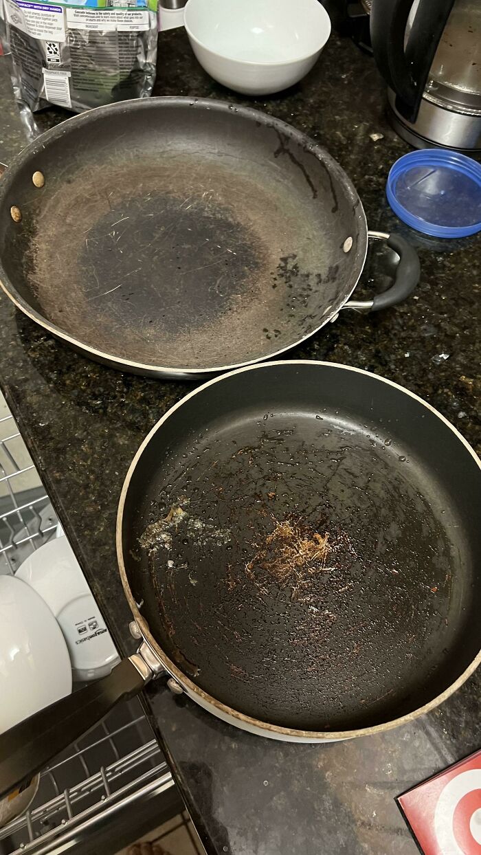 Old, dirty frying pans on a kitchen counter, illustrating weaponized incompetence in household chores.