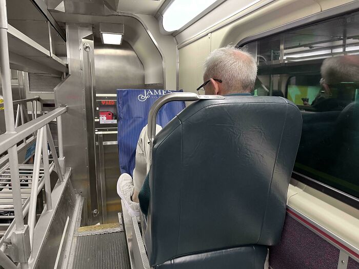Passenger on public transport taking up space with a shopping bag, viewed from behind.