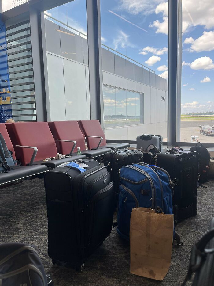 Unattended luggage blocking airport seats, highlighting annoying plane passengers.