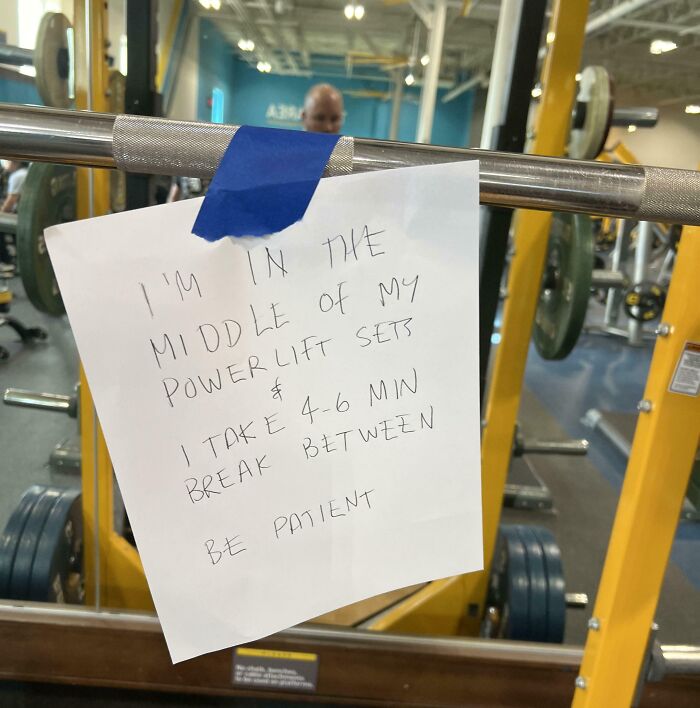 Gym sign on barbell with a note causing frustration by taking extended breaks.
