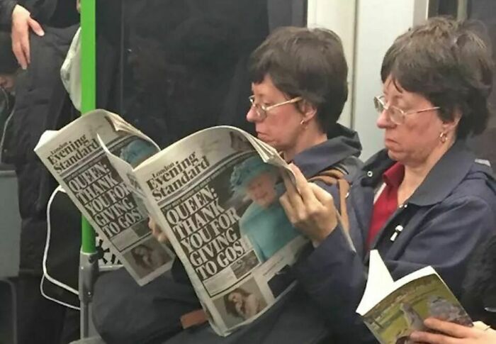 Two women on a train reading newspapers, appearing as uncanny doppelgangers, highlighting a matrix glitch.