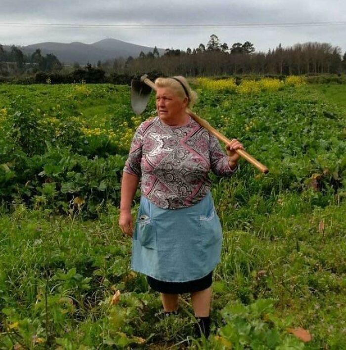 Woman in a field with a shovel over her shoulder, illustrating uncanny doppelgangers in the Matrix.