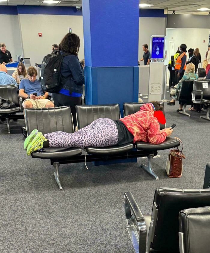 Passenger sprawled across airport seats, displaying annoying-plane-passengers behavior.