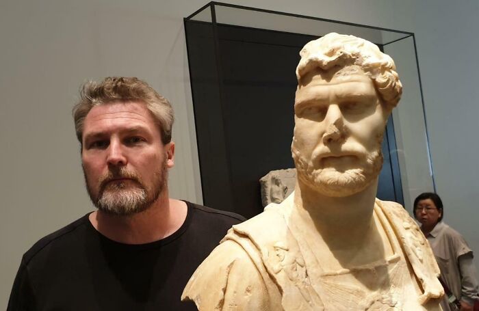 Man posing next to a statue with uncanny resemblance, illustrating glitches in the matrix and doppelgangers.