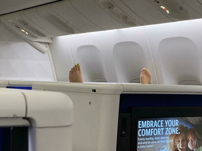 Feet resting on a plane wall, showcasing typical annoying plane passengers behavior.