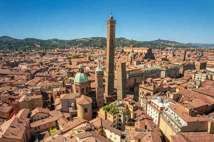 Aerial view of historic cityscape featuring impressive architectural feats with ancient towers and domed buildings under clear sky.