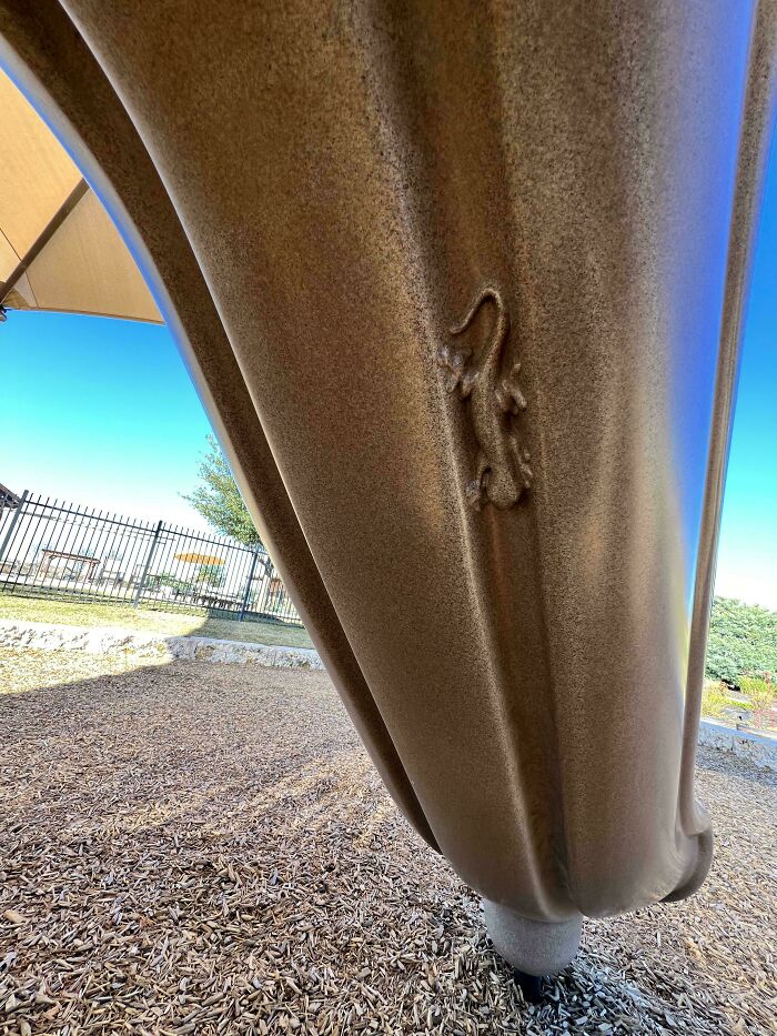 Genius design detail of a lizard relief on a slide, showcasing exceptional creativity and craftsmanship.