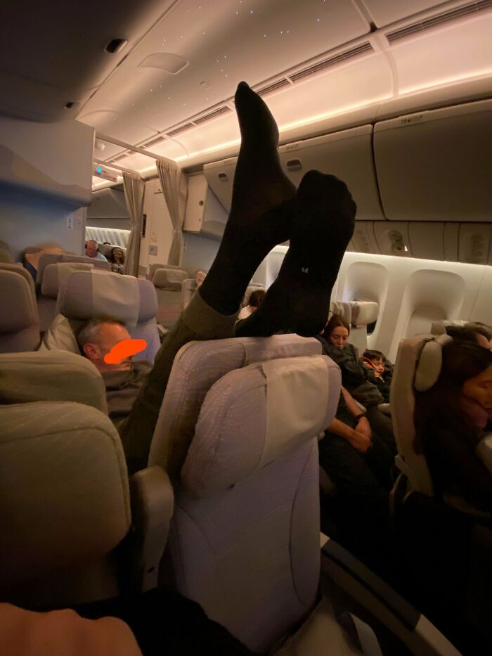Passenger with feet up on plane seat, representing annoying plane passengers behavior.