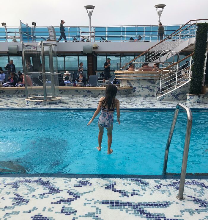 Child appearing to walk on water in a pool, creating an interesting optical illusion, not Photoshopped.