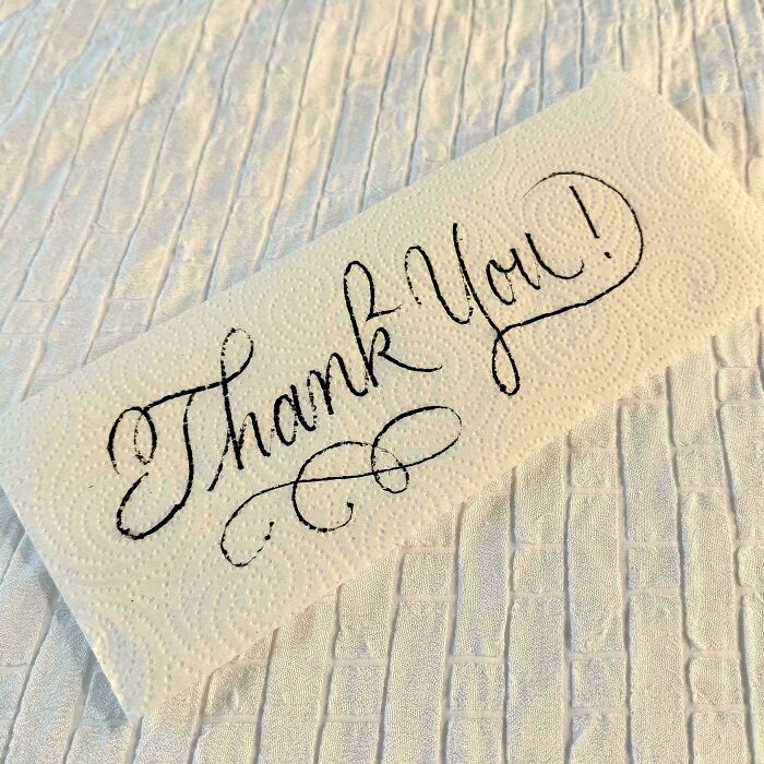 Elegant handwritten "Thank You" on a paper towel showcasing exceptional handwriting skills.