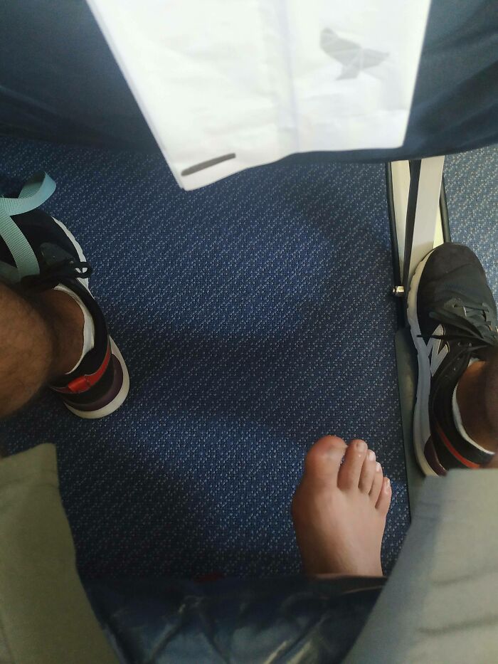 Barefoot passenger next to someone wearing sneakers on a plane, illustrating annoying plane passengers.