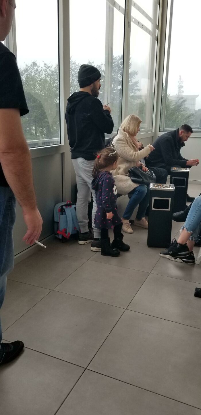 People sitting and standing near windows, some using phones, potentially illustrating annoying plane passengers behavior.
