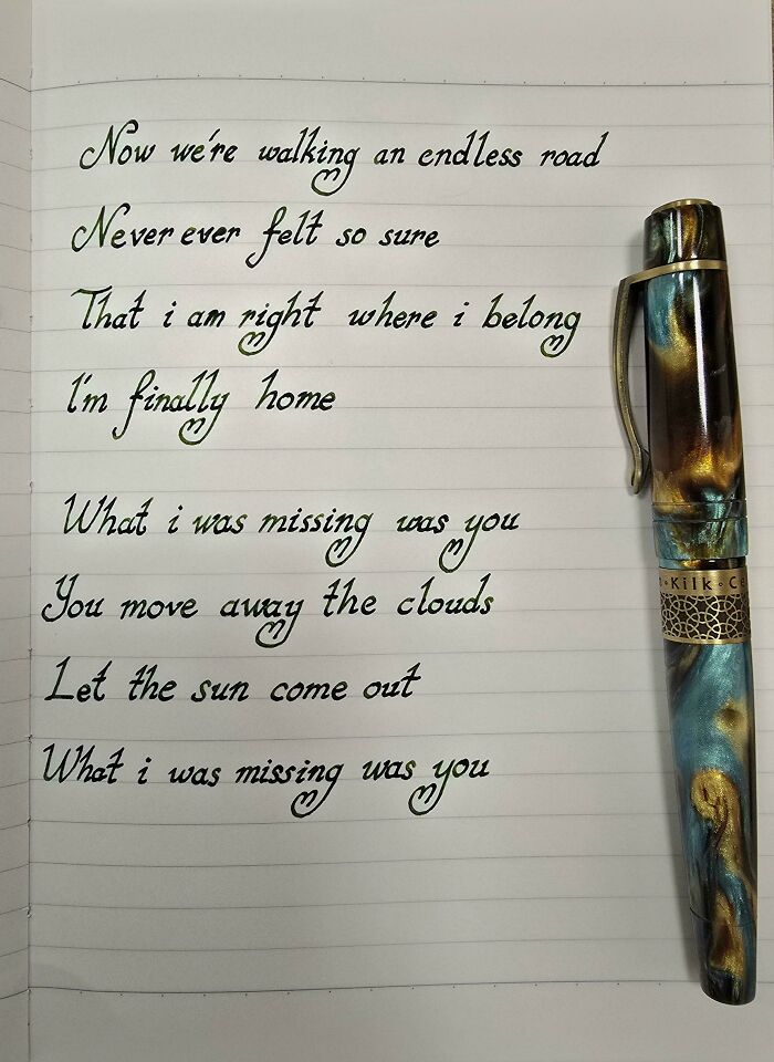 Elegant handwriting on lined paper with a decorative pen, showcasing artistic handwriting skills.