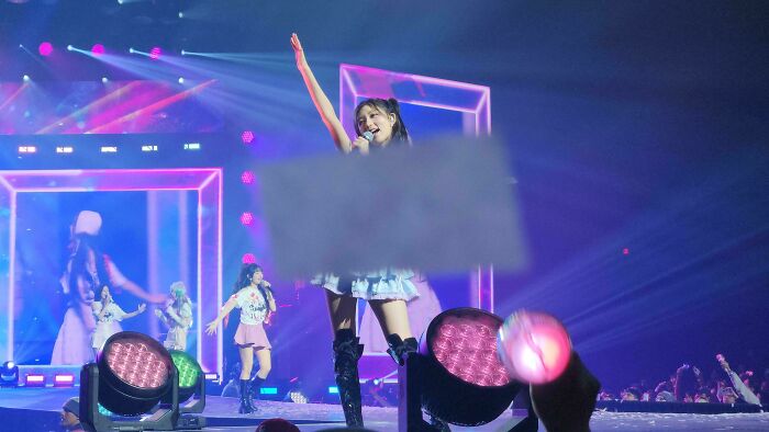 Performer on stage during a vibrant concert with colorful lights, showing an interesting not photoshopped scene.