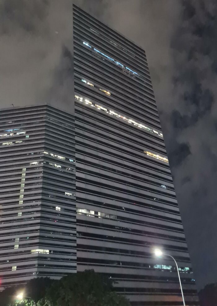 Tall building at night with lights creating an optical illusion; interesting not photoshopped photo.