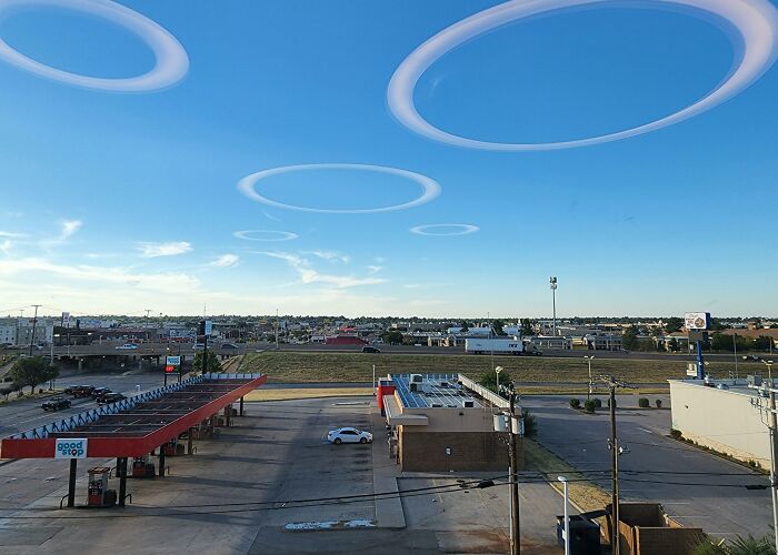 Unusual sky with circular cloud formations over an empty gas station, showcasing interesting not photoshopped photos.