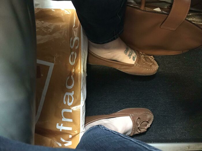 Two passengers' feet cramped in close quarters on a plane, highlighting annoying-plane-passengers.